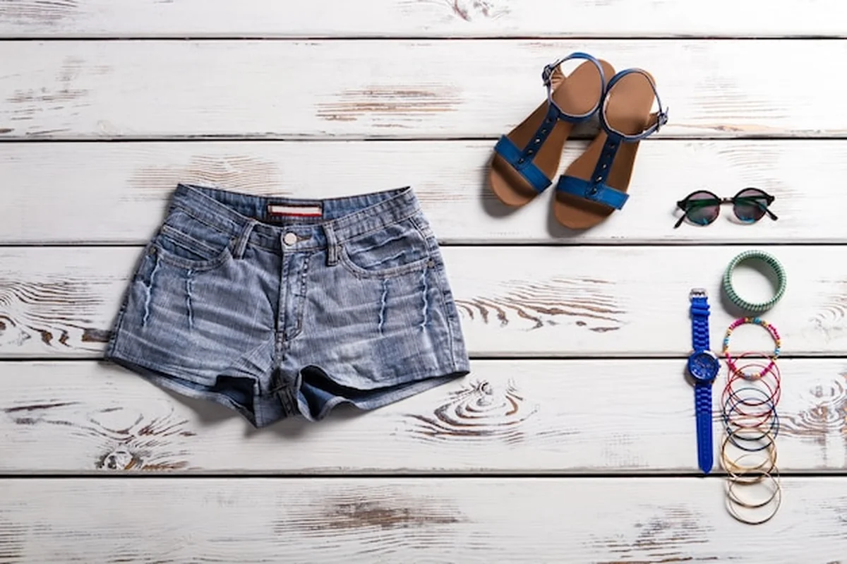Klasyczne dżinsowe szorty, sandały i drobne akcesoria w letniej stylizacji vintage