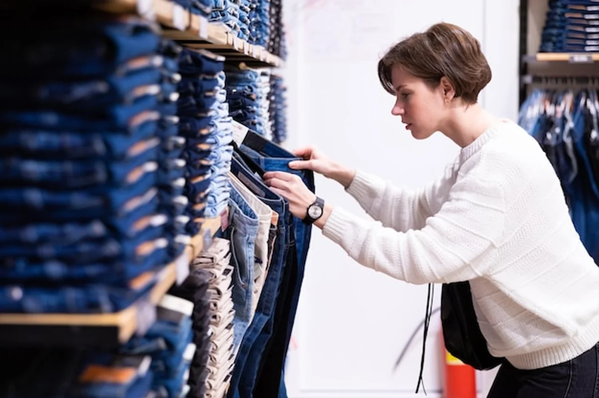 Młoda kobieta kupuje dżinsy w dyskoncie