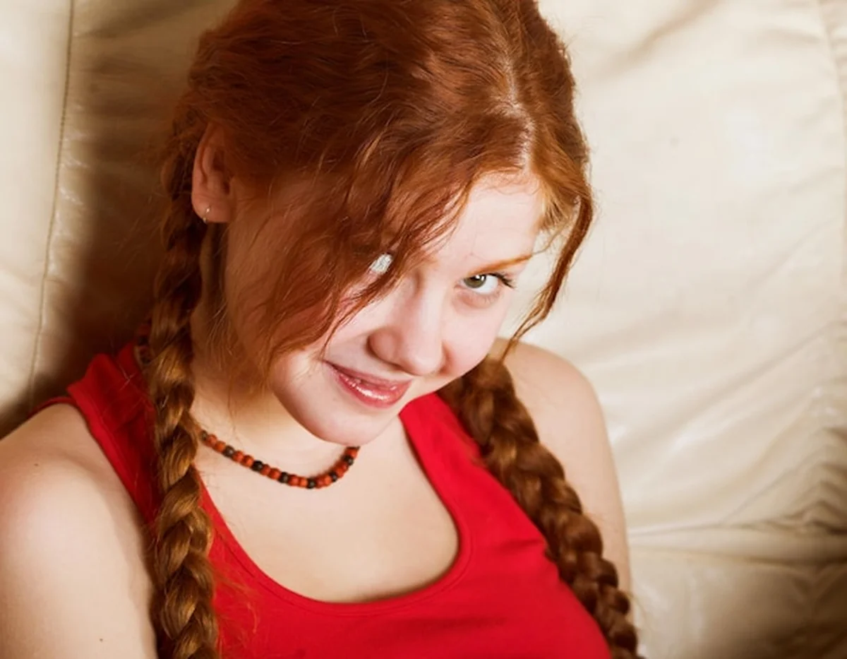 Piękna rudowłosa dziewczyna z długimi warkoczami