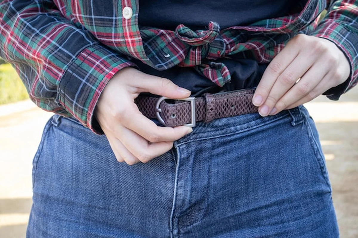 Młoda dziewczyna przywiązuje pas do spodni