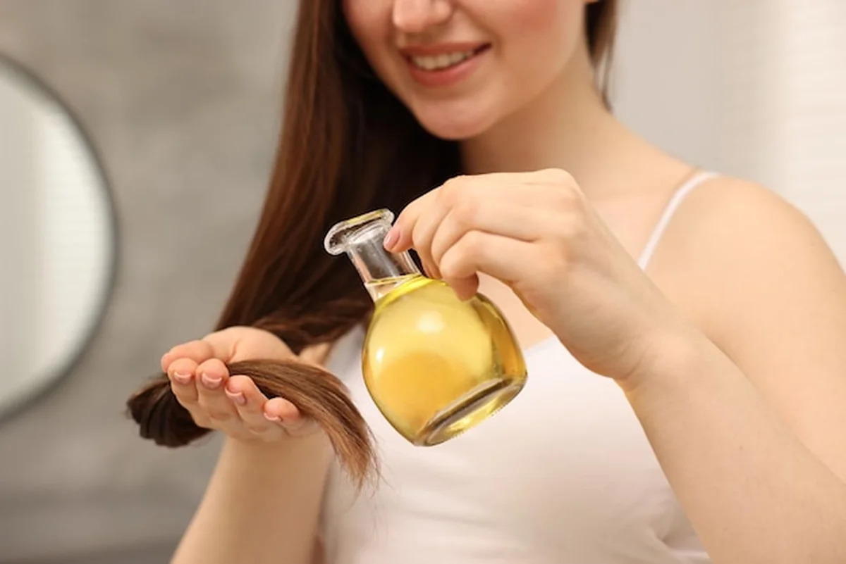 Kobieta nakładająca maskę olejową na włosy w domu