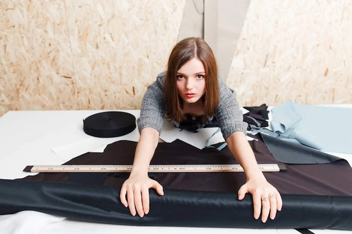 Kobieta krawiecka wycinająca wzory na materiale