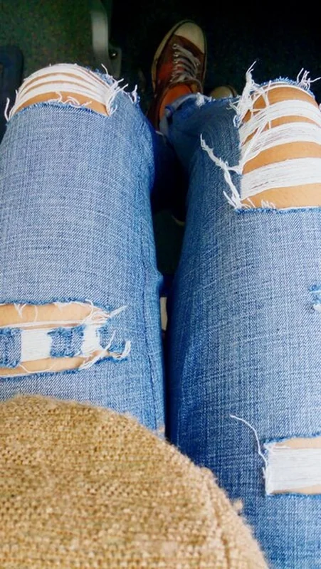 Dolna część osoby w rozerwanych dżinsach