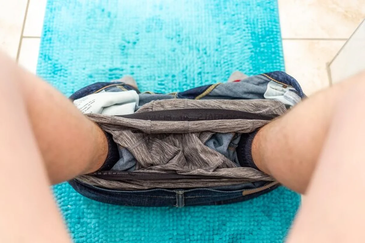 Mężczyzna z dżinsami na dywanie w domu