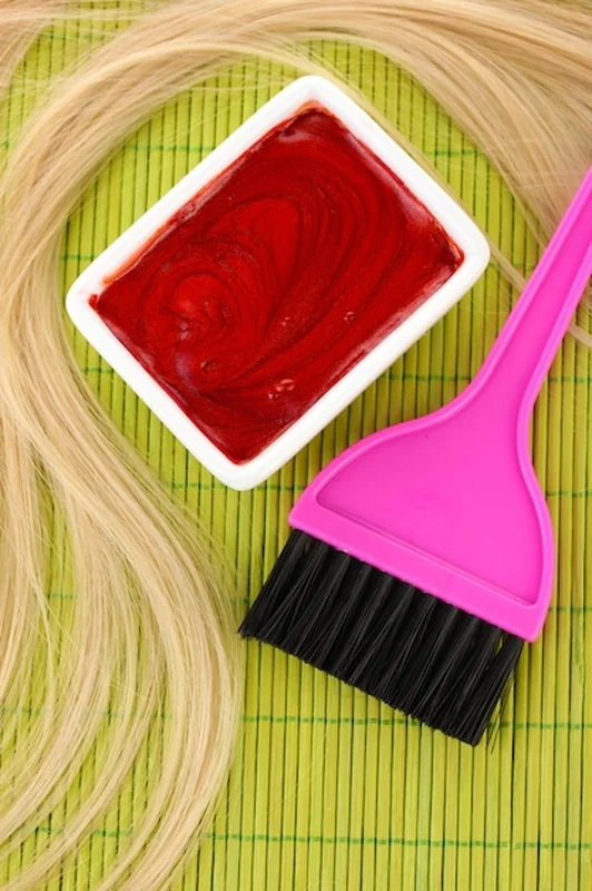 Farba do włosów w misce i pędzel do farbowania włosów na zielonej macie bambusowej