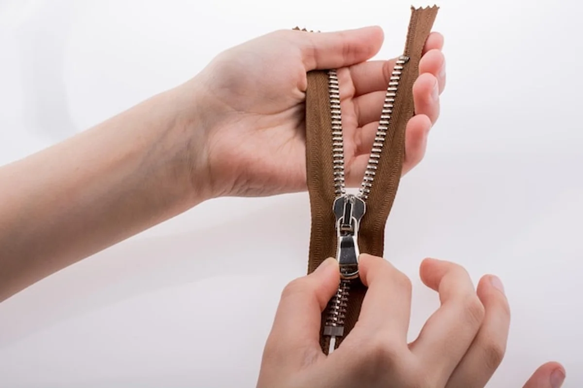 Ręka trzymająca zamek błyskawiczny