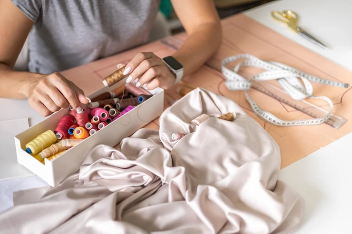 Kobieta krawcowa dobiera kolor nitki do szycia