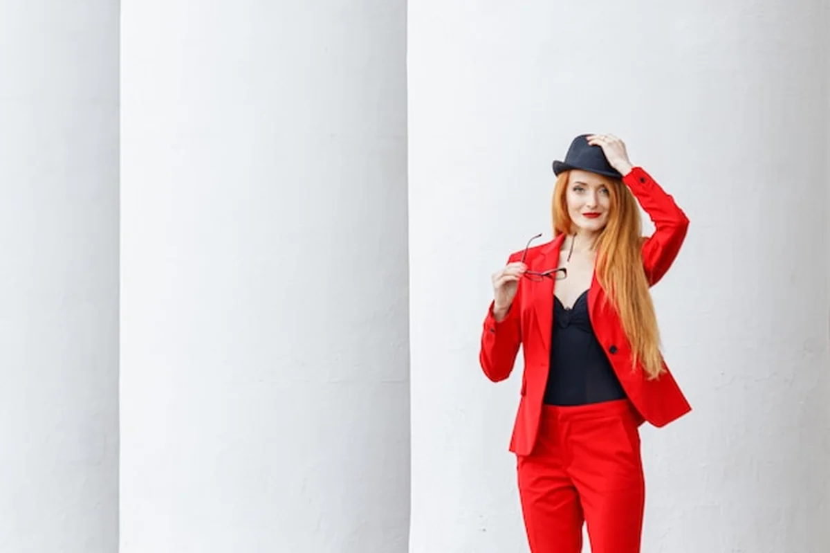 Piękna dziewczyna z rudymi włosami w czerwonym garniturze Biznesowy portret