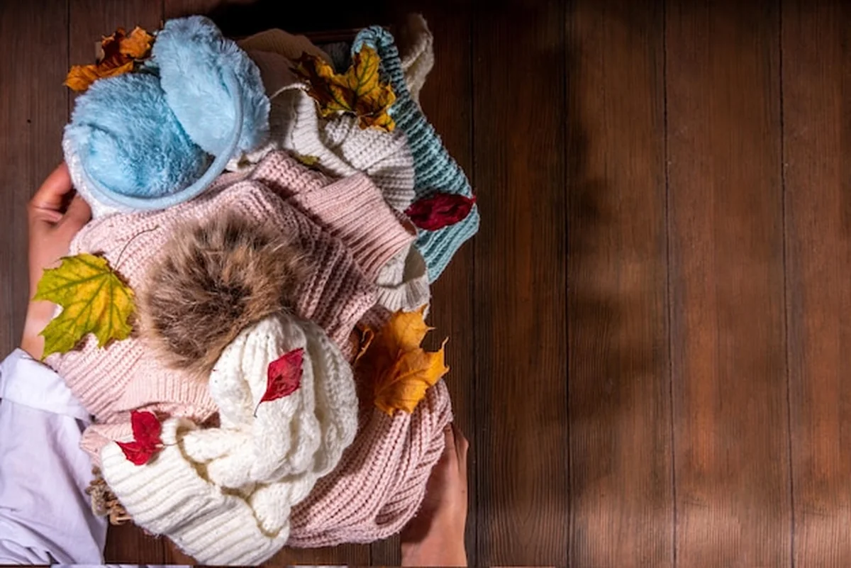 Ciepłe, przytulne swetry zrolowane w szufladzie komody
