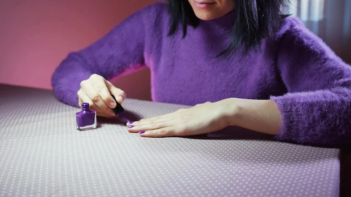 Kobieta nakładająca lakier do paznokci