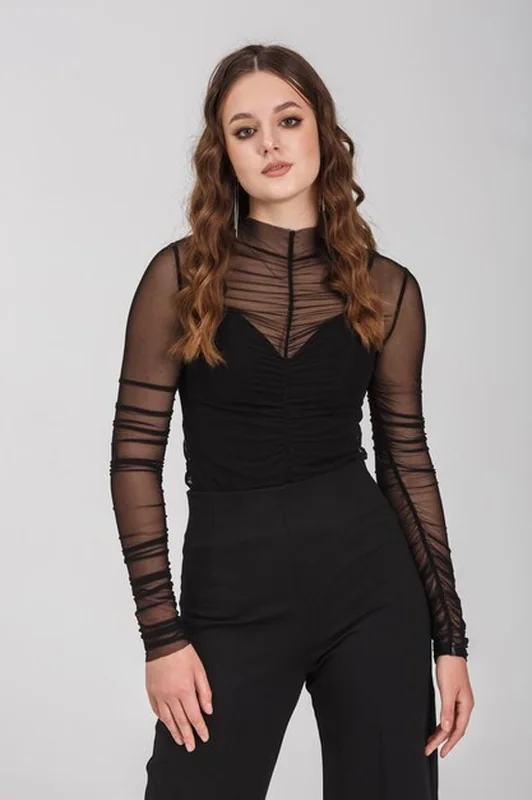 Modelka w czarnej koszuli i spodniach na białym tle