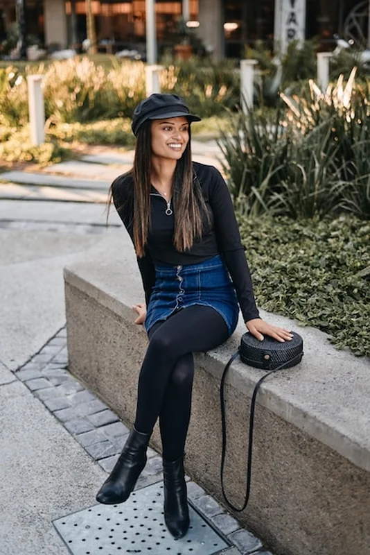 Młoda kobieta w eleganckim stroju siedząca w parku