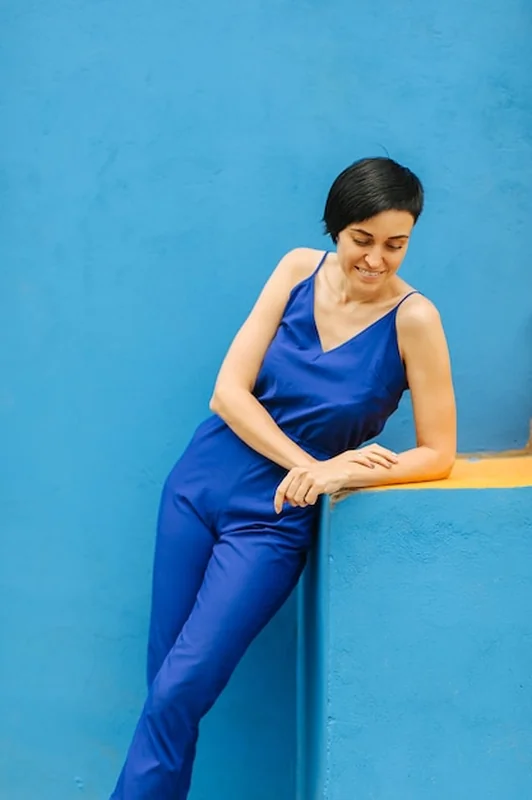 Kobieta w niebieskich ubraniach na jasnym niebieskim tle w mieście