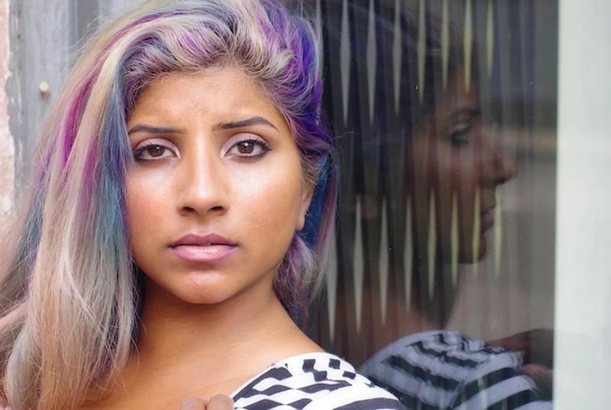 Kobieta z farbowanymi włosami przy oknie