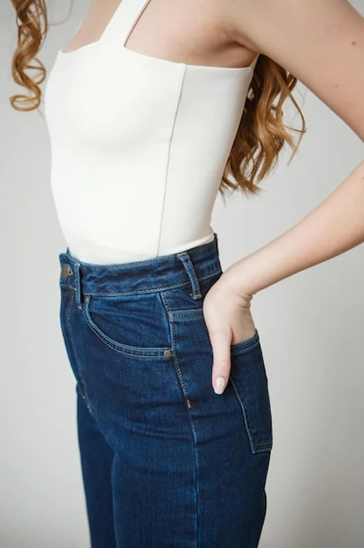 Nogi w dżinsach do pięknej dziewczyny na białym tle