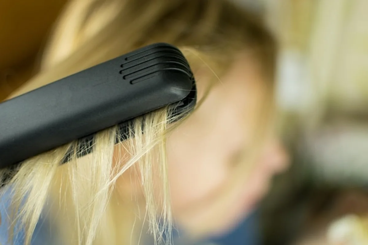 Wyrównywanie kobiecych włosów żelazkiem do włosów