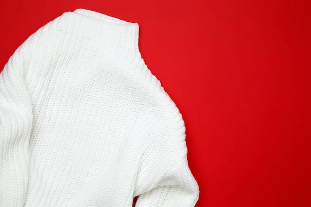 Biały sweter na czerwonym tle