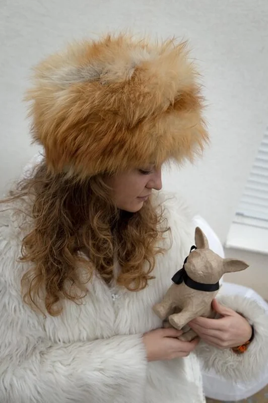 Kobieta w ciepłych ubraniach trzymająca figurkę psa