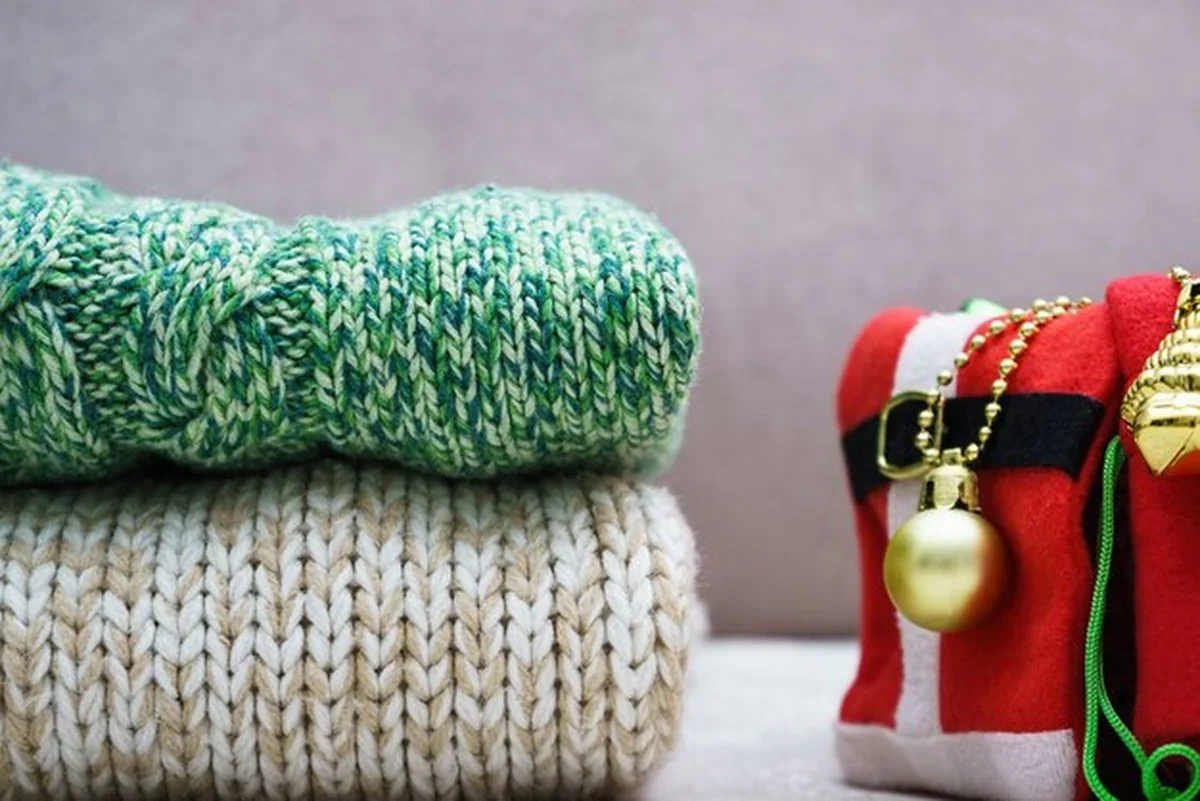 Stos ciepłej dzianiny i ozdób choinkowych