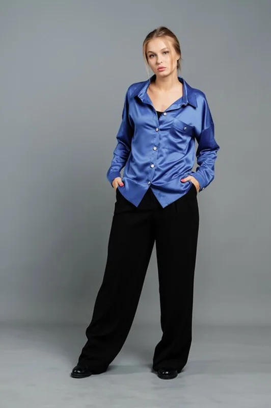 Kobieta w bluzce i szerokich spodniach