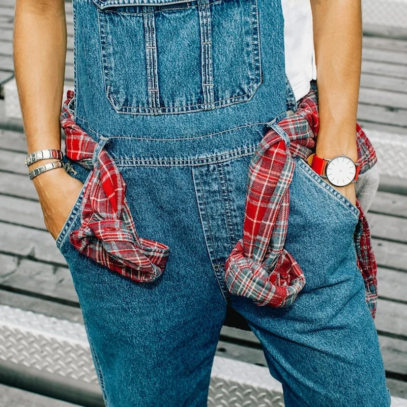 Stylowa miejska dziewczyna w dżinsowym kombinezonie