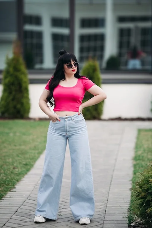 Kobieta w dżinsach culotte i jasnym topie na ulicy