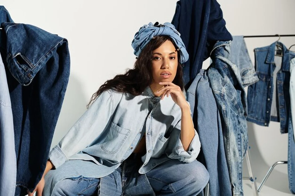 Modna kobieta w stylu dżinsowym w letnim otoczeniu