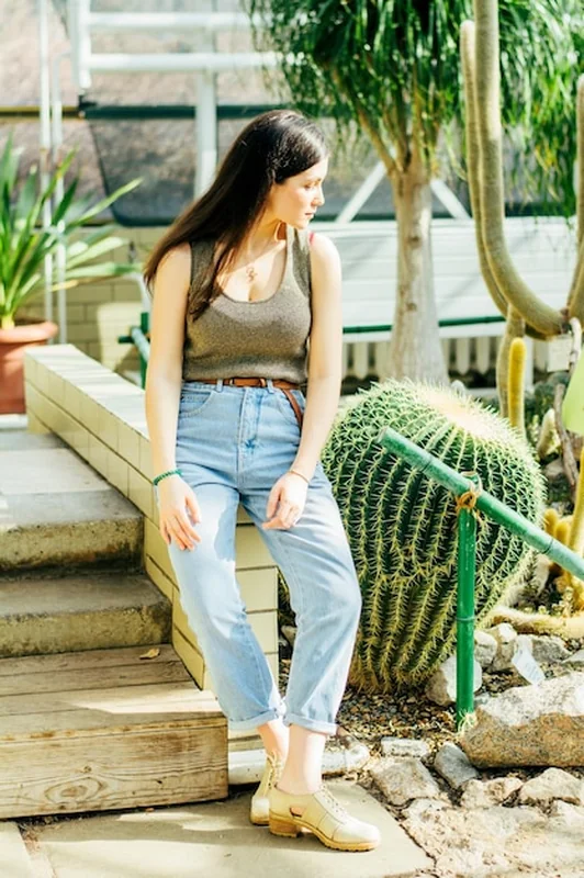 Brunetka w niebieskich dżinsach w ogrodzie botanicznym