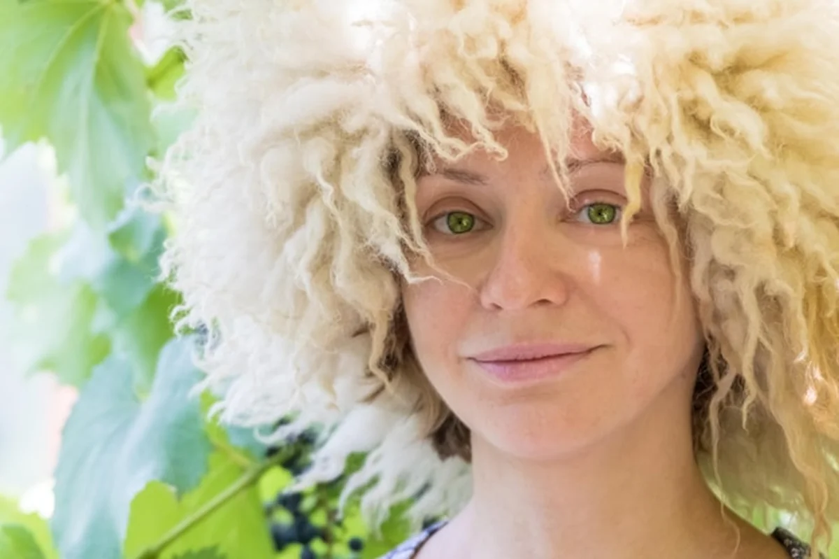 Kobieta nosząca futrzaną czapkę w ogrodzie winogronowym